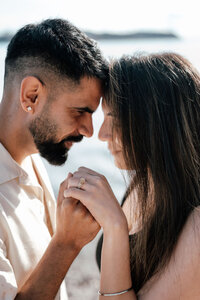 Close-up of Harleen and Jayse holding hands during their beach proposal photoshoot, with engagement ring visible as they embrace, photographed by Auckland proposal photographer Zanthe Vorsatz.