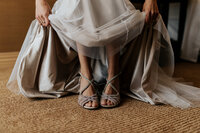 bride holding dress in hands and showing heels