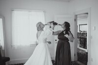Bride and her maid of honor drinking champagne at a Boston area wedding. Photography by Rhode Tripper Photography