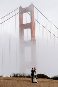newlyweds kiss in front of golden gate bridge