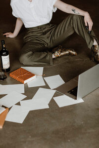 A website copywriter sitting on the floor organizing papers for a messaging strategy project