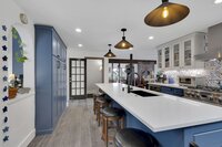 A beautiful kitchen with a blue island and cabinets. 