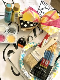 Paint party supplies with paint brushes, bows, and paint