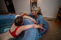 Midwife supporting a person during water birth.