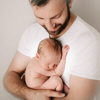 newborn baby sleeping in dad's arm in raleigh nc