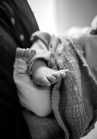 tiny newborn feet in a black and white image