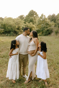 family maternity photos in a field