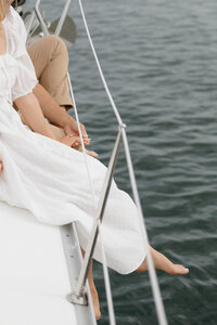 Feet hanging off the side of a sailboat 