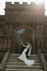 groom dipping bride in front of church