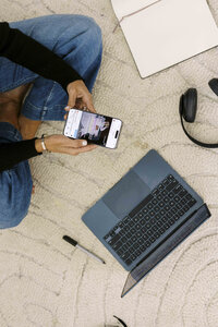 Tarah sitting on floor on Instagram and computer
