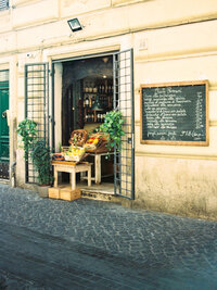 Outdoor café with tables on a cobblestone street in Europe.