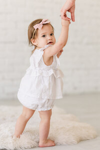 baby-girl-holding-moms-hand-portrait-session-at-the-lumen-room