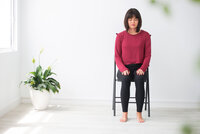 Woman sitting on chair with eyes closed