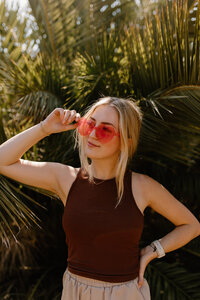 woman holding sunglasses on face