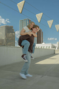 couple piggybacking and spinning on roof top