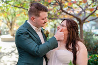 bride cries, groom wipes tear