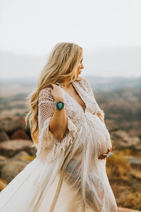 blonde pregnant mother in a white fringe gown at sunset in the Wichita Mountain Wildlife Refuge