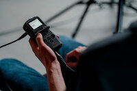 A Storyteller team member's hands holding an audio monitor.