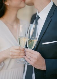 挙式後に乾杯しながらキスするカップル