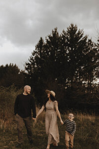 Parents holding hands with toddler while walking in Bangor, Wisconsin