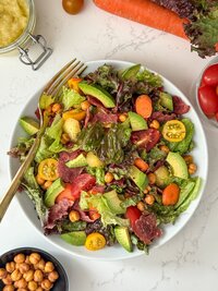 A salad with turkey bacon, lettuce , cherry tomatoes and avocado.
