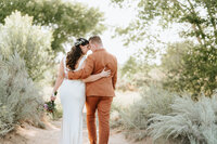 Bride and groom walking in the desert at Prairie Star Resort.