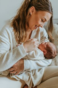 A woman holds and comforts a newborn baby.