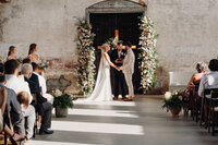 Mother of the bride helping bride get into dress