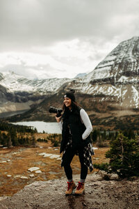 a photographer posing in front of glacier national park views