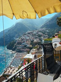 View of Amalfi Coast from a balcony with a yellow beach umbrella