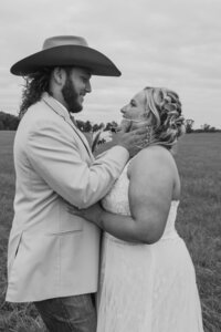 Black and white photo of a groom holding the bride's face in his hands