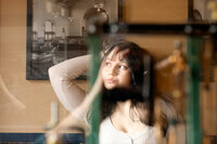 High school senior looking past reflections in a glass window.