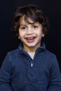 little boy with with dark hair smiling