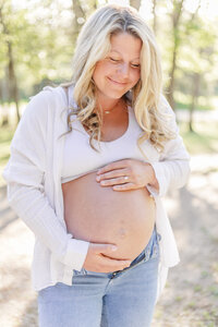 An expecting mother smiling and holding her belly