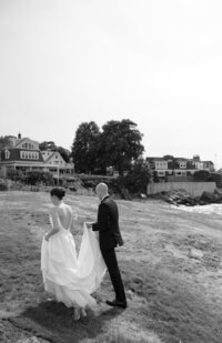 Bride and Groom walk hand in hand at Marblehead Neck during their wedding portraits.