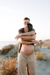 Expectant parents at maternity photoshoot on Perth beach