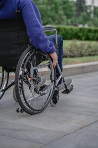 Person in a wheelchair navigating an outdoor public space, symbolizing the Americans with Disabilities Act (ADA), a federal law that prohibits disability discrimination and requires businesses to provide equal access and reasonable accommodations in areas like employment, transportation, and public facilities.