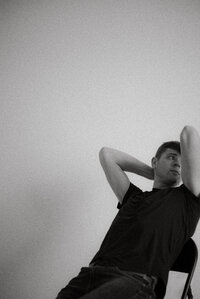 Nate Leaning back in chair black and white image