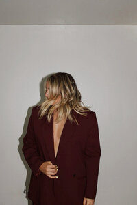 An aesthetic image of a stylish woman in a striking blazer, emphasizing strong brand aesthetics. Ideal for website design inspiration for fashion boutiques or creative businesses looking for a visually appealing website.