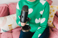 Woman in green sweater with a microphone