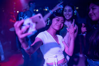 Fans at an outdoor music festival  dance  with lights and confetti