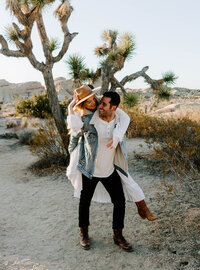 man carries woman in desert for Palm Springs elopement