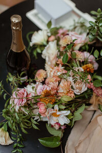 Wedding centerpieces next to champagne bottle