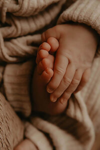 A close up shot of a newborn boy holding his feet in Canandaigua, NY