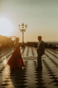 woman in red dress dances with man in Taormina Square