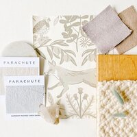 Flatlay Interior Palette Scheme of Light Wood, Textured Neutral Fabrics, Parachute Bedding, Hygge & West Wallpaper with Fox , and Bunny Tail