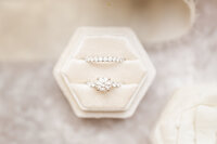 A bride's wedding and engagement rings sit in their box