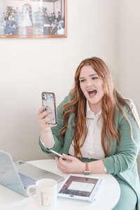 Elyse Stokes on the phone with a client, generating excitement for their live wedding painting and wedding day