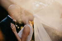 Coppia di sposi che si guardano romanticamente baciati dagli ultimi raggi di sole presso villa di Bivigliano.