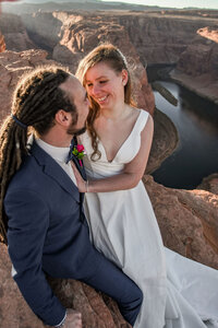A couple celebrating their engagement at Horseshoe Bend during a sunset proposal, with the glowing colors of the canyon and river creating a romantic atmosphere.